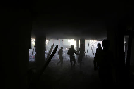 Palestinians run inside a building that was hit by an Israeli air strike, in the southern Gaza Strip May 5, 2019. REUTERS/Ibraheem Abu Mustafa