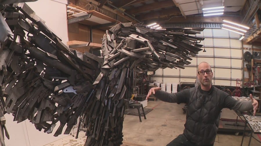 Travis Pond stands next to his in-progress eagle sculpture that honors the military. April 19, 2024 (KOIN).