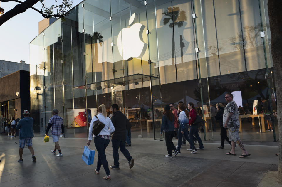 In this Saturday June 15, 2019 photo pedestrians walk past an Apple store along the 3rd Street Promenade in Santa Monica, Calif. On Tuesday, June 25, the Conference Board releases its June index on U.S. consumer confidence. (AP Photo/Richard Vogel)
