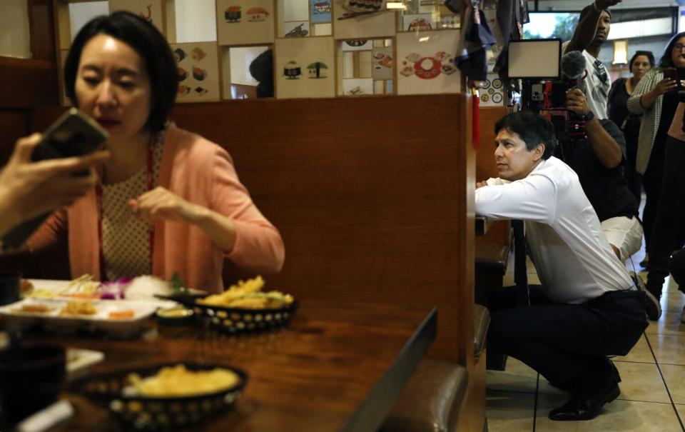 Mayoral candidate Kevin de León, right, chats with patrons in Koreatown on Monday evening.