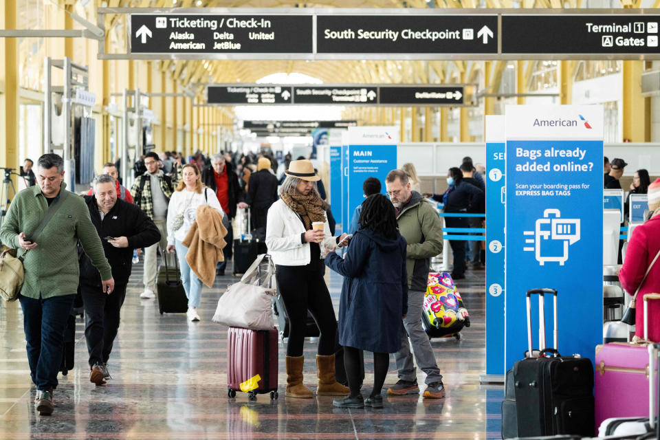 Travelers walk through a terminal at Ronald Reagan Washington National Airport (Saul Loeb / AFP via Getty Images)