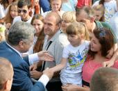 Ukrainian President Petro Poroshenko (L) greets a young girl during National Flag Day celebrations in Kiev on August 23, 2016