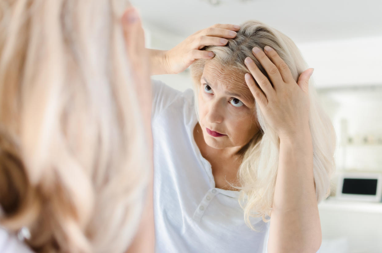 Woman checking for hair in front of mirror