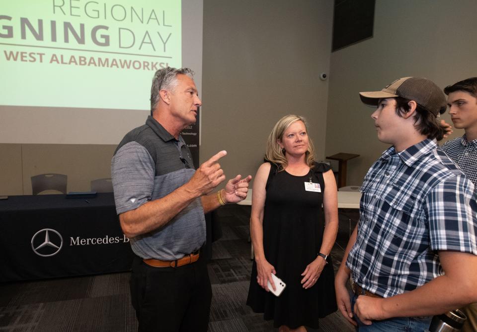 May 11, 2022; Tuscaloosa, AL, USA; Mercedes-Benz representative Steve Colburn talks to Brookwood High teacher Jennifer Lindeman and student Philip Langley at the Tuscaloosa Career and Technology Academy Signing Day Wednesday. TCTA prepares students with a technical education in preparation for graduates entering the work force. Signing day gives the students an opportunity to sign employment or apprenticeship agreements with local employers. Gary Cosby Jr.-The Tuscaloosa News