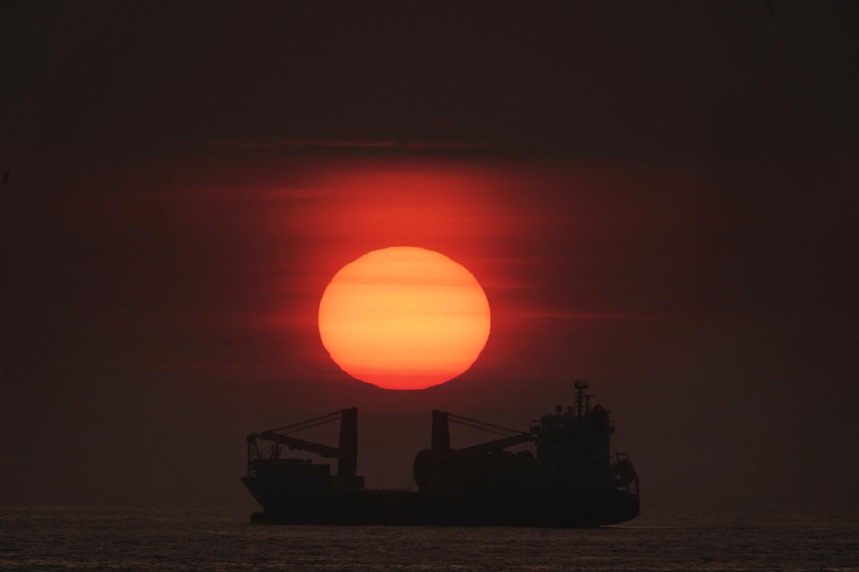 The sun rises through the mist over a BBC Fuji Cargo Ship anchored just of the north east coast at Tynemouth. Picture date: Tuesday July 16, 2019. A partial lunar eclipse is set to be visible across parts of the UK on Tuesday, if clear weather and conditions hold up. See PA story WEATHER Sunrise. Photo credit should read: Owen Humphreys/PA Wire