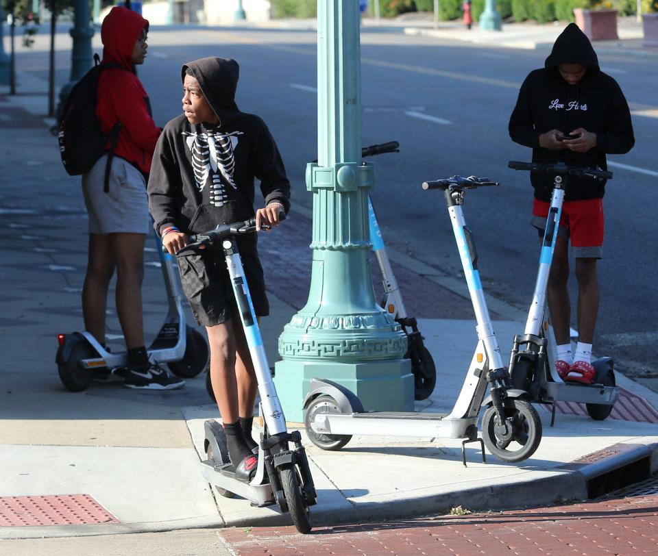 Tezzy Gordon rides a Bird scooter through Canton in late June. The city and company say the scooters have been popular with residents since they were introduced more than two months ago.
