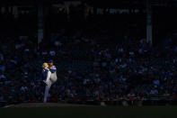 Chicago Cubs starting pitcher Marcus Stroman, lit by the setting sun, winds up during the first inning of the team's baseball game against the Washington Nationals on Tuesday, Aug. 9, 2022, in Chicago. (AP Photo/Charles Rex Arbogast)