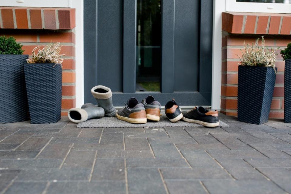 Three pairs of shoes outside front door of house