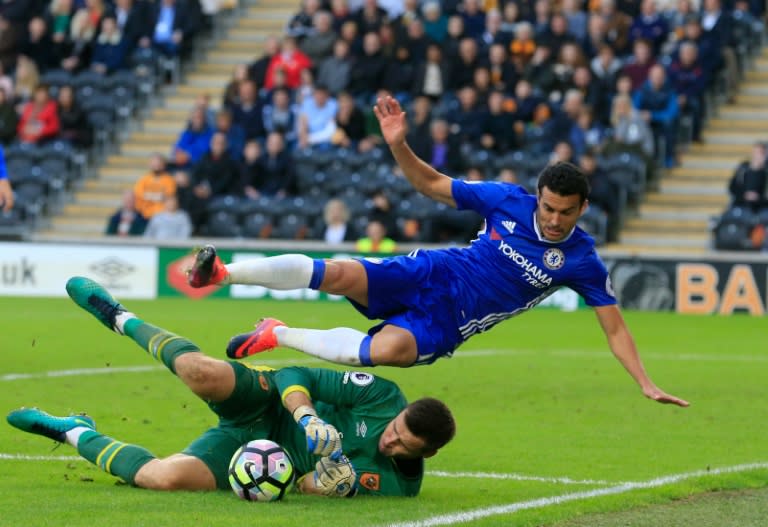 Hull City's Scottish goalkeeper David Marshall (L) makes a save under pressure from Chelsea's Spanish midfielder Pedro