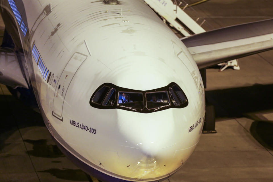 The pilot sits on the plane, that will transport the passengers from the Australian cruise ship Greg Mortimer at the international airport in Montevideo, Uruguay, Saturday, April 11, 2020. Uruguay evacuated Australians and New Zealanders Friday from the cruise ship that has been anchored off the South American country coast since March 27 with more than half its passengers and crew infected with the new coronavirus. (AP Photo/Matilde Campodonico)