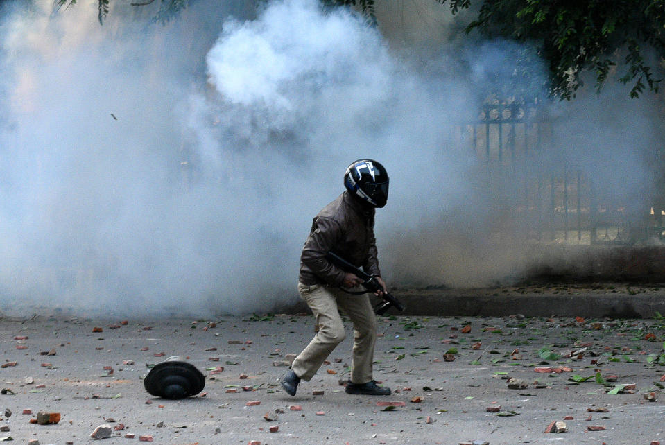 LUCKNOW, INDIA - DECEMBER 19: Police personnel fire tear gas shells towards demonstrators during an anti Citizenship Amendment Act (CAA) and National Register of Citizens (NRC) protest at Parivartan Chowk area on December 19, 2019 in Lucknow, India. The act seeks to grant Indian citizenship to refugees from Hindu, Christian, Sikh, Buddhist and Parsi communities fleeing religious persecution from Pakistan, Afghanistan, and Bangladesh, and who entered India on or before December 31, 2014. The Parliament had passed the Citizenship (Amendment) Bill, 2019 last week and it became an act after receiving assent from President Ram Nath Kovind. Since then, protests including some violent ones have erupted in various regions of the country, including the North East over the amended citizenship law. (Photo by Dheeraj Dhawan/Hindustan Times via Getty Images)