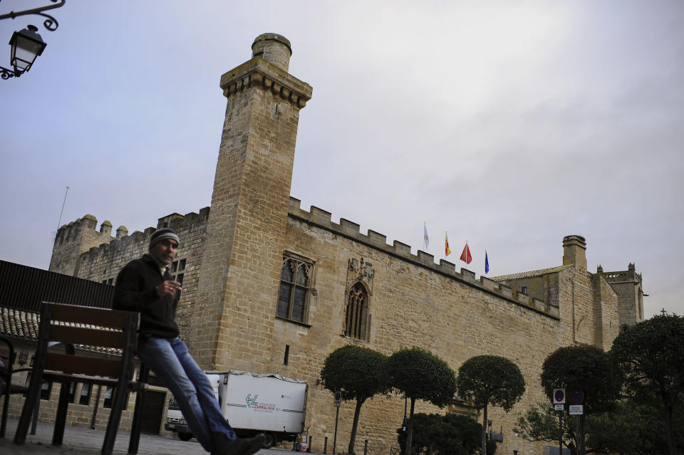 A man rests beside at parador hotel of Principe de Viana, in Olite, northern Spain on Friday, Dec. 7, 2012. Employees of Spain's premium hotel chain Parador, a state-run group that uses castles, monasteries and palaces, are holding a two-day strike to protest job cuts and possible closures. The Parador hotels group, which started in 1928, says a drop in demand could leave it with accumulated losses of euro107 million ($140 million) by the end of the year. It intends to cut 644 jobs out of a workforce of 4,400. (AP Photo/Alvaro Barrientos)