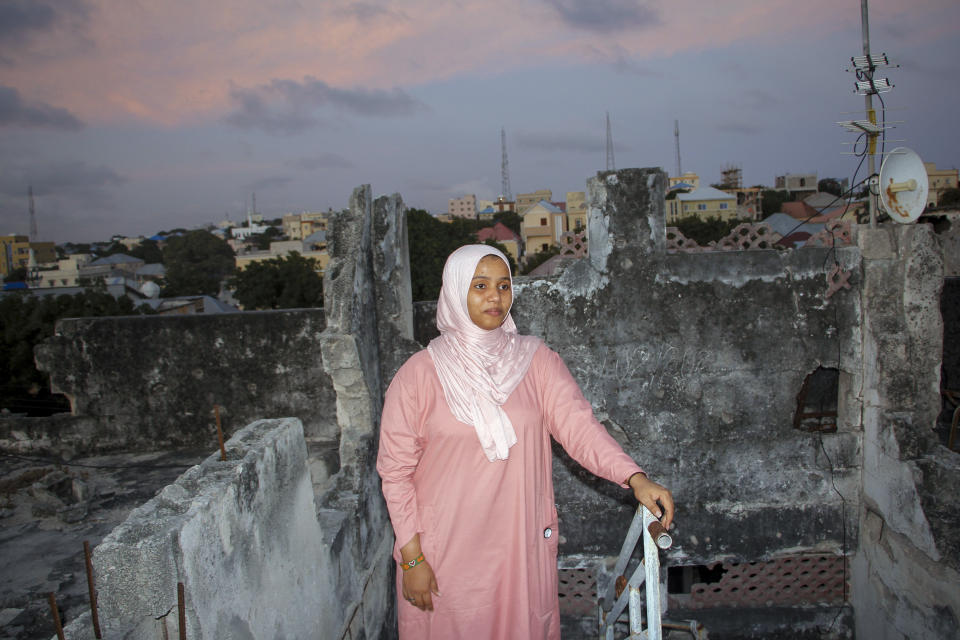 Somali artist Sana Ashraf Sharif Muhsin, 21, is photographed on the roof of her home overlooking the capital Mogadishu, Somalia Friday, Oct. 15, 2021. Among the once-taboo professions emerging from Somalia's decades of conflict and Islamic extremism is the world of arts, and this 21-year-old female painter has faced more opposition than most. (AP Photo/Farah Abdi Warsameh)