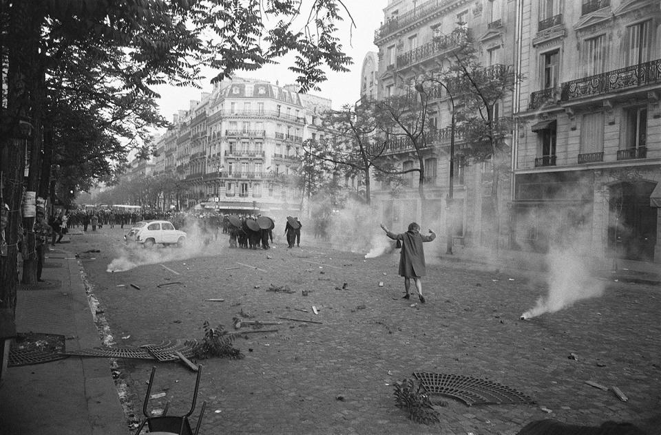 <p>On the first day of violence during student riots, a young woman challenges shield-bearing CRS police in a cloud of tear gas at Place Mabillon on the Boulevard Saint-Germain in Paris, May 6, 1968. (Photo: Gökşin Sipahioğlu/SIPA) </p>