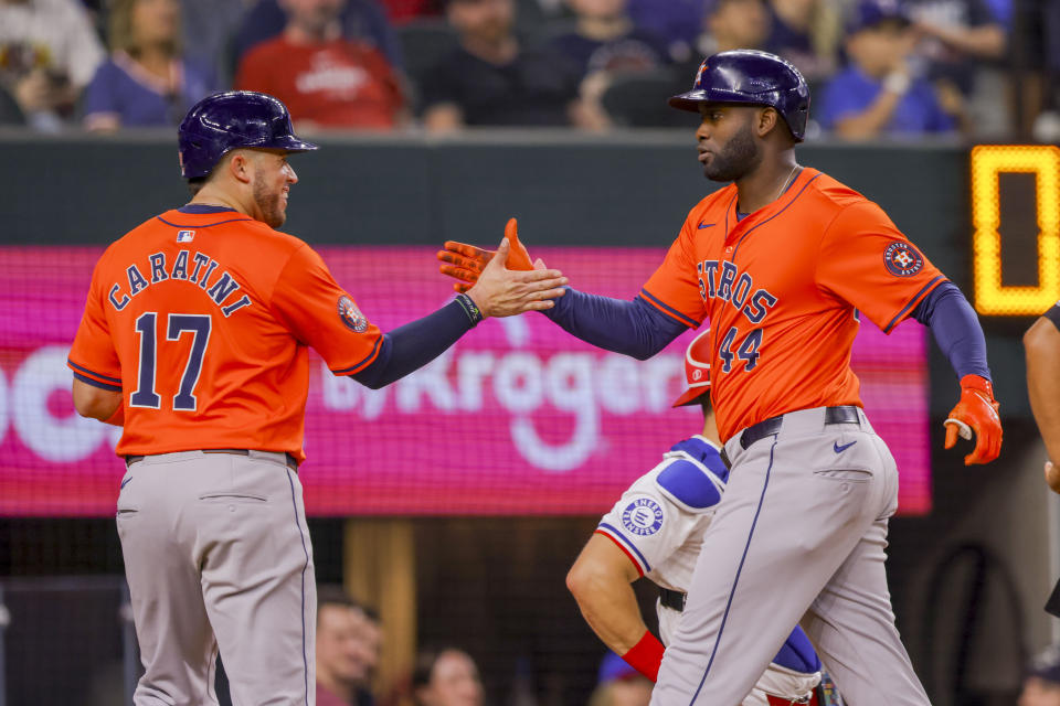 Houston Astros' Victor Caratini (17) and teammate Yordan Alvarez (44) celebrate after Alvarez hit a two-run home run during the second inning of a baseball game against the Texas Rangers, Monday, April 8, 2024, in Arlington, Texas. (AP Photo/Gareth Patterson)