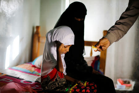 Afaf Hussein, 10, who is malnourished, sits next to her stepmother as her father Hussein Abdu, 40, gives her a slice of an orange at a hotel in Sanaa, Yemen, February 14, 2019. Afaf, who now weighs around 11 kg and is described by her doctor as "skin and bones", has been left acutely malnourished by a limited diet during her growing years and suffering from hepatitis, likely caused by infected water. She left school two years ago because she got too weak. "Before the war we managed to get food because prices were acceptable and there was work ... Now they have increased significantly and we rely on yogurt and bread for nutrition," said Abdu. REUTERS/Khaled Abdullah