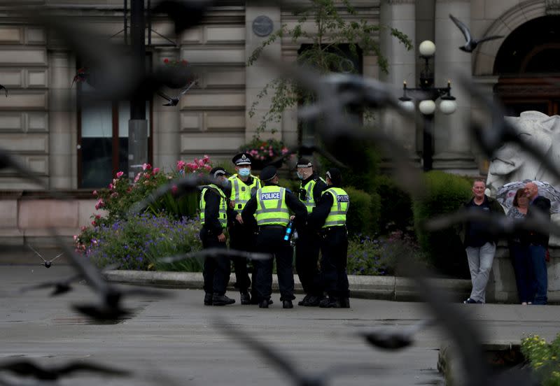 Police officers stand at George Square in Glasgow