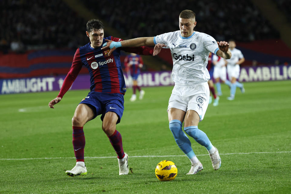 FILE -Barcelona's Andreas Christensen, left, and Girona's Artem Dovbyk challenge for the ball during the Spanish La Liga soccer match between Barcelona and Girona at the Olimpic Lluis Companys stadium in Barcelona, Spain, Sunday, Dec. 10, 2023. Bologna, Stuttgart and Girona are most strongly favored to be in the 36-team Champions League lineup when the lucrative format starts in September.(AP Photo/Joan Monfort, File)