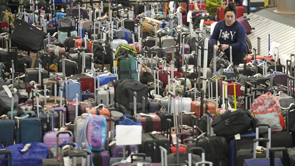 A Southwest Airlines employee looks for an unclaimed bag at Southwest Airlines baggage claim at Salt Lake City International Airport Thursday, Dec. 29, 2022, in Salt Lake City. Southwest Airlines is still trying to extract itself from sustained scheduling chaos and cancelled another 2,350 flights after a winter storm overwhelmed its operations days ago. (AP Photo/Rick Bowmer)