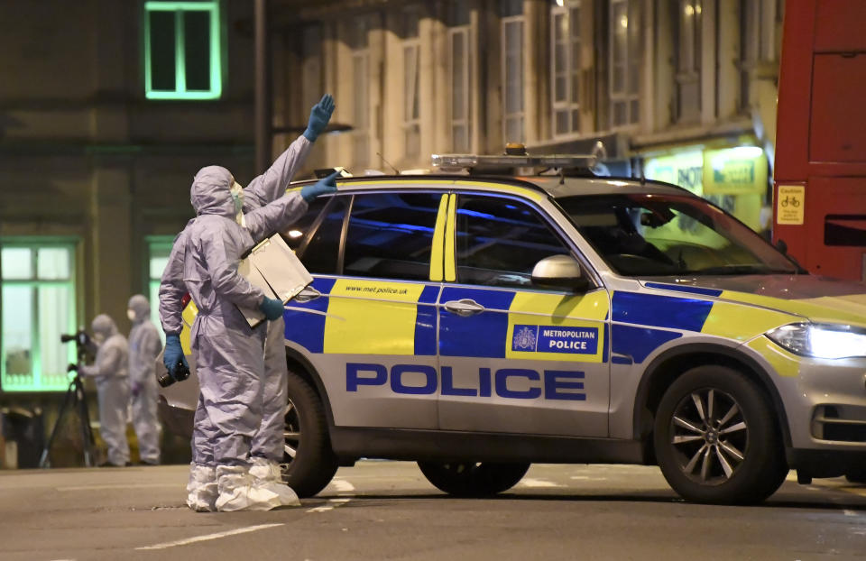 Police forensic officers work near the scene after a stabbing incident in Streatham London, England, Sunday, Feb. 2, 2020. London police officers shot and killed a suspect after at least two people were stabbed Sunday in what authorities are investigating as a terror attack. (AP Photo/Alberto Pezzali)