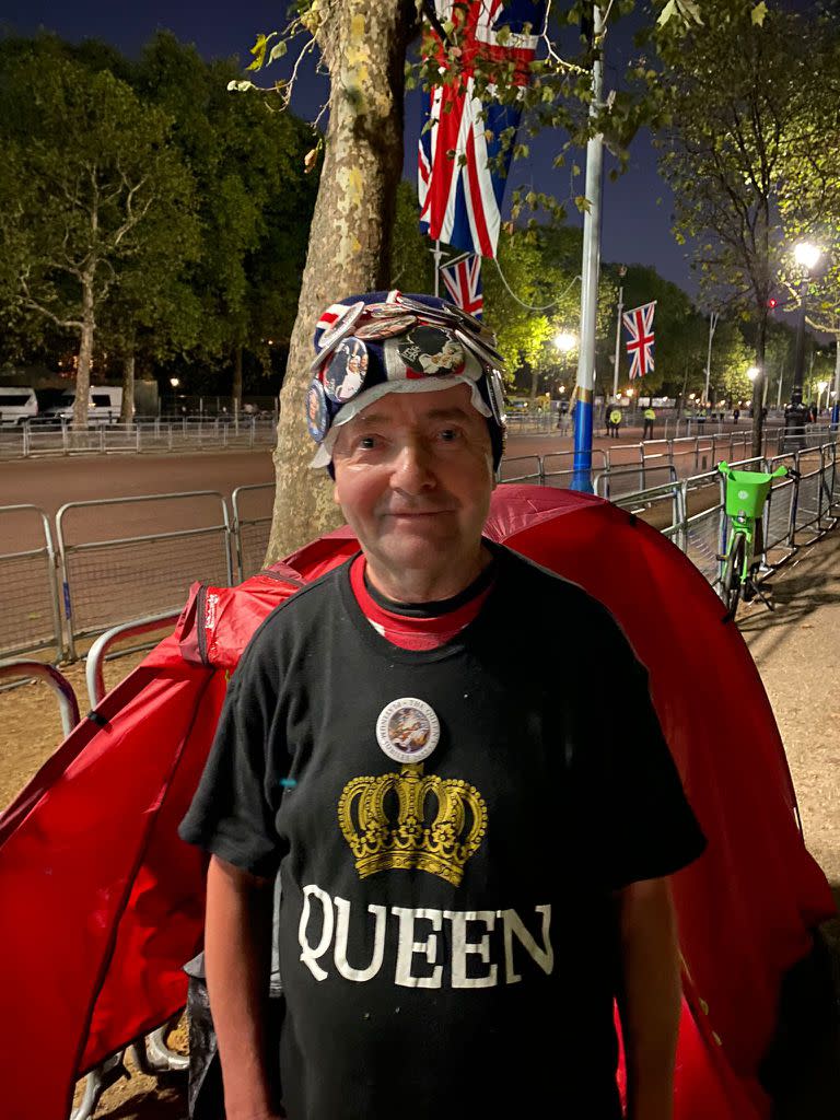 John lleva puesto un gorro con la Union Jack repleto de pins con fotos de la realeza