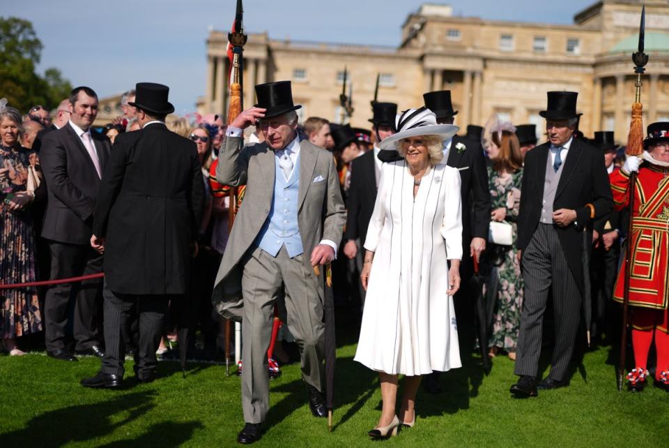 Charles wore a grey suit and light blue waistcoat and tie, while Camilla wore a white silk dress by Fiona Clare and a hat by Philip Treacy (Jordan Pettitt/PA Wire)