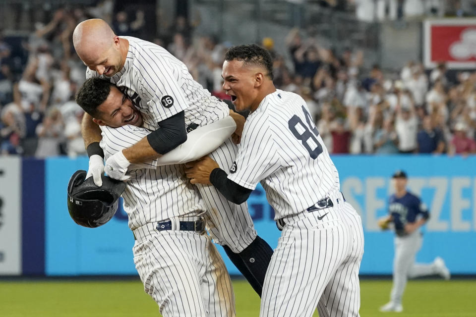 New York Yankees' Brett Gardner, center, celebrates his walkoff winning an RBI-single with Albert Abreu (84) and Gleyber Torres in the 11th inning of a baseball game against the Seattle Mariners, Friday, Aug. 6, 2021, in New York. (AP Photo/Mary Altaffer)