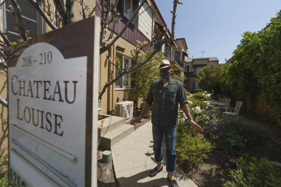 Nathan Long, a video game writer, walks outside his rental apartment communal garden in Glendale, Calif., Thursday, April 8, 2021. He and his wife, Lili, have been unsuccessful so far in their search for a home in Los Angeles. (AP Photo/Damian Dovarganes)