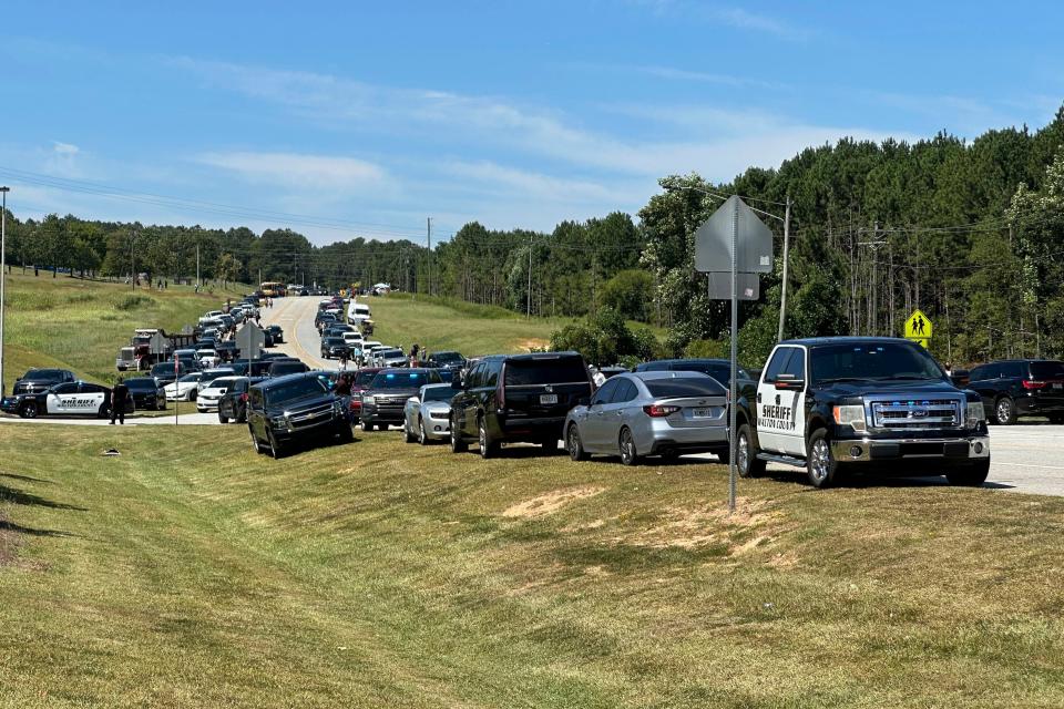 Law enforcement arrive as students are evacuated to the football stadium after the school campus was placed on lockdown at Apalachee High School in Winder, Ga., on Wednesday, Sept. 4, 2024. (AP Photo/Jeff Amy)