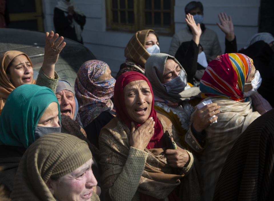 Relatives and family members cry near the coffin of Basharat Ahmad Zargar in Srinagar, Indian-controlled Kashmir, Sunday, Feb.14, 2021. Zargar, who was working at a power project, was among the dozens killed after a part of a Himalayan glacier broke off on February 7 sending a devastating flood downriver slamming into two hydropower projects in northern India. (AP Photo/Mukhtar Khan)