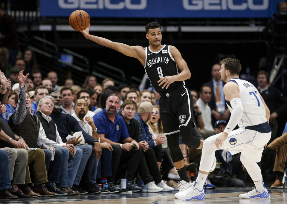 Brooklyn Nets guard Timothe Luwawu-Cabarrot (9) reaches for the ball as Dallas Mavericks forward Luka Doncic (77) defends during the first half of an NBA basketball game Thursday, Jan. 2, 2020, in Dallas. (AP Photo/Brandon Wade)