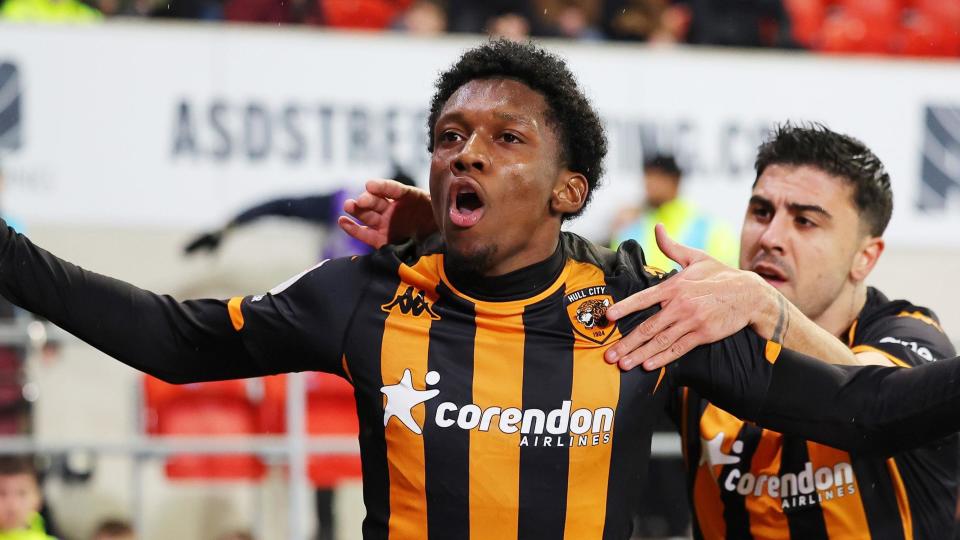 Jaden Philogene, wearing Hull's black and orange home strip, celebrates a goal with his arms outstretched