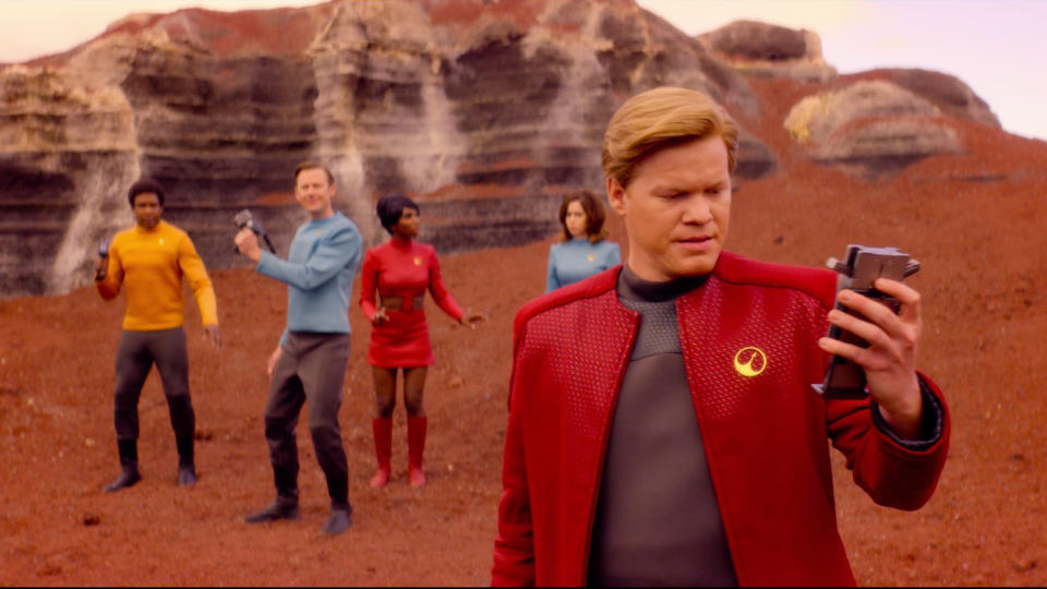 a group of people (l-r, Osy Ikhile, Jimmi Simpson, Michaela Coel, Cristin Milioti, and Jesse Plemons) wearing Star-Trek style outfits and carrying metal gadgets, in the Black Mirror season 4 episode USS Callister