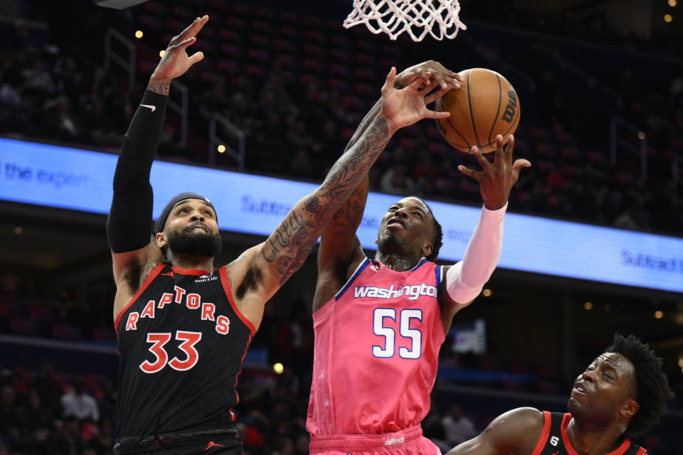 Toronto Raptors guard Gary Trent Jr. (33) and forward O.G. Anunoby, lower right, battle for the ball against Washington Wizards guard Delon Wright (55) during the first half of an NBA basketball game, Thursday, March 2, 2023, in Washington. (AP Photo/Nick Wass)