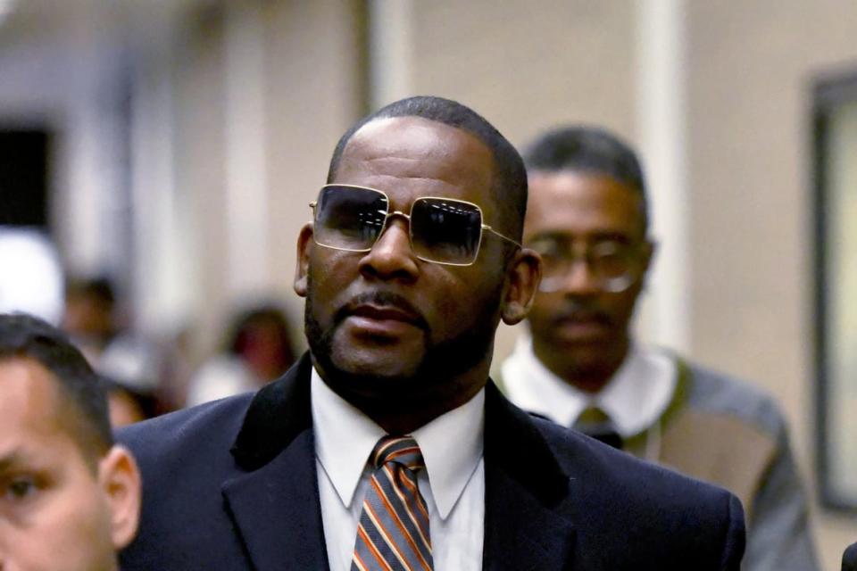 R. Kelly, center, leaves the Daley Center after a hearing in his child support case May 8, 2019, in Chicago. Federal prosecutors asked a judge Thursday, Feb. 16, 2023, to give singer R. Kelly 25 more years in prison for his child pornography and enticement convictions last year in Chicago, which would add to 30 years he recently began serving in a New York case. (AP Photo/Matt Marton, File)