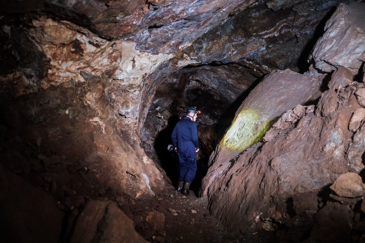 Professor Lee Berger walks inside the Rising Star cave system in The Cradle of Human Kind, near Johannesburg, South Africa, May 11, 2023, as he uses his light checking for the presence of fossils in the Dolomite rock which composes the cave. / Credit: LUCA SOLA/AFP/Getty