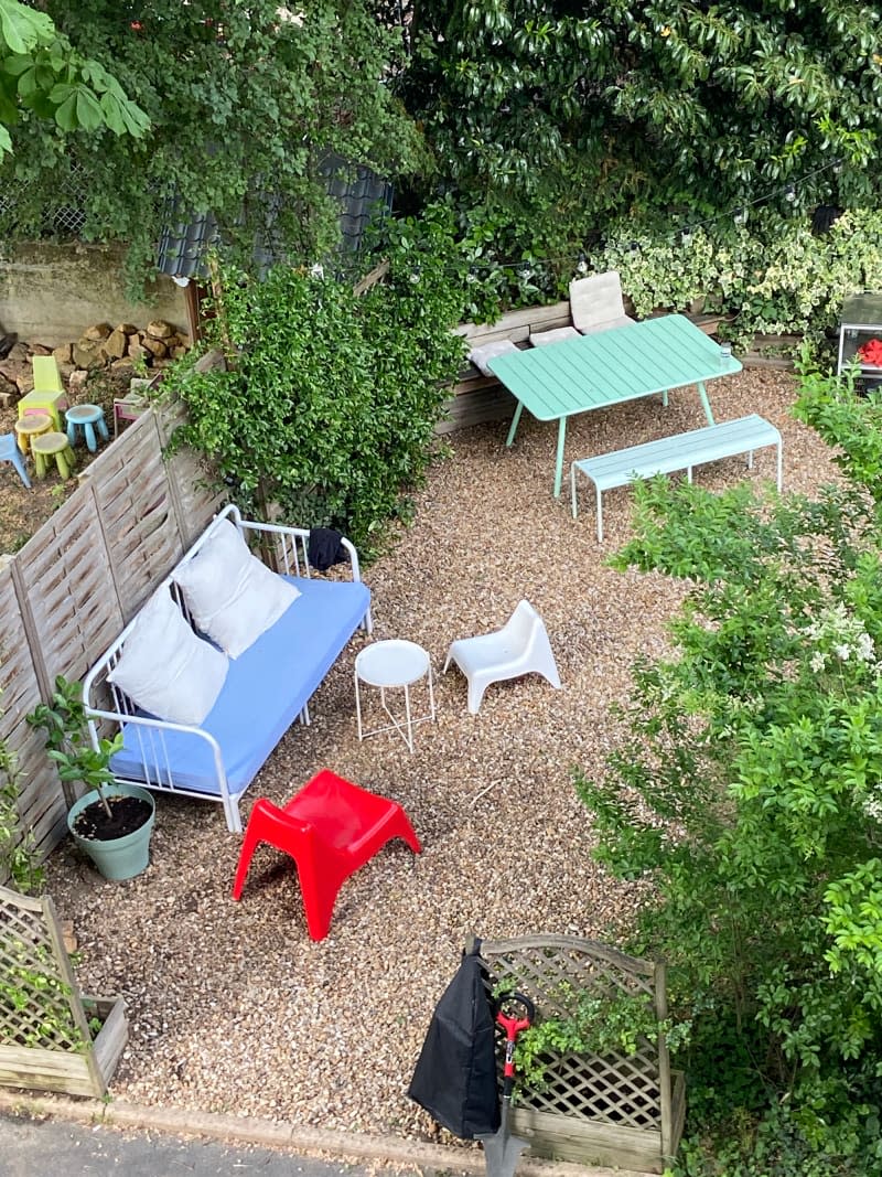 Overhead view of graveled backyard with lounge and dining furniture.