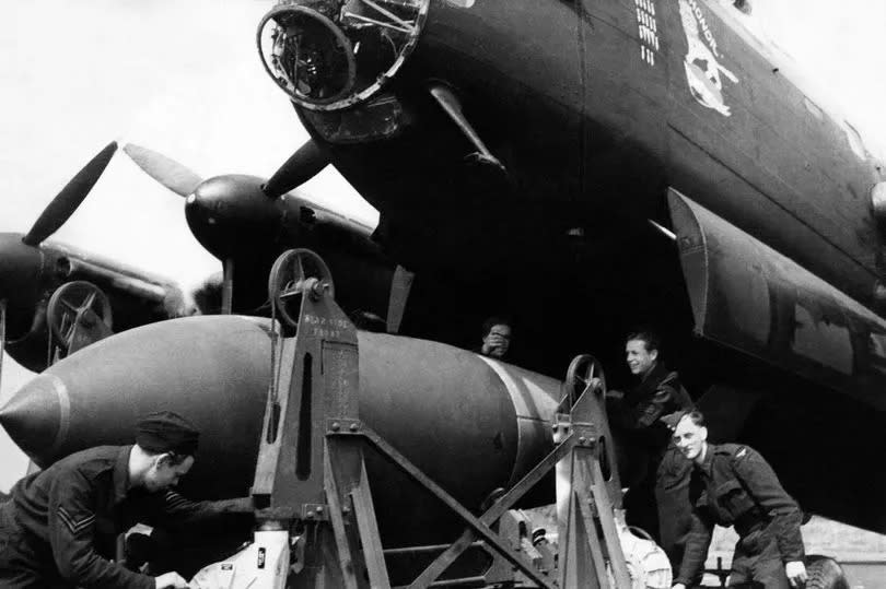 Bomber command load one of the new 12,000 pound "earthquake" bombs onto a Lancaster II bomber, the same bombs that sunk the 45,000 ton German battleship Tirpitz in Norway. 14th October 1944. (Photo by Daily Mirror Library/Mirrorpix/Mirrorpix via Getty Images)