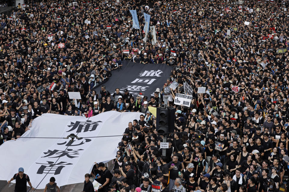 Protesters carry a huge banner that reads "Our hearts are torn to pieces. Withdraw the monstrous bill" as they march on the streets against an extradition bill in Hong Kong on Sunday, June 16, 2019. Hong Kong residents Sunday continued their massive protest over an unpopular extradition bill that has highlighted the territory's apprehension about relations with mainland China, a week after the crisis brought as many as 1 million into the streets. (AP Photo/Vincent Yu)