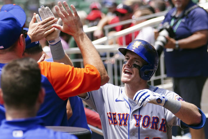 New York Mets' Mark Canha celebrates in the dugout after hitting a home run in the sixth inning of a baseball game against the Atlanta Braves Wednesday, July 13, 2022, in Atlanta. (AP Photo/John Bazemore)