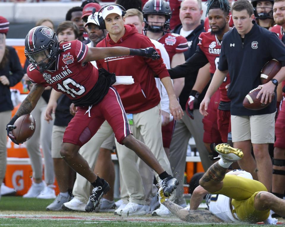 South Carolina Gamecocks wide receiver Ahmarean Brown (10) goes out of bounds on a first quarter play for a first down under the watch of South Carolina Gamecocks head coach Shane Beamer.  The University of Notre Dame Fighting Irish took on the University of South Carolina Gamecocks in the TaxSlayer Gator Bowl game in Jacksonville, Florida's TIAA Bank Field Friday, December 30, 2022. The first half ended with South Carolina holding a 24 to 17 lead. [Bob Self/Florida Times-Union]