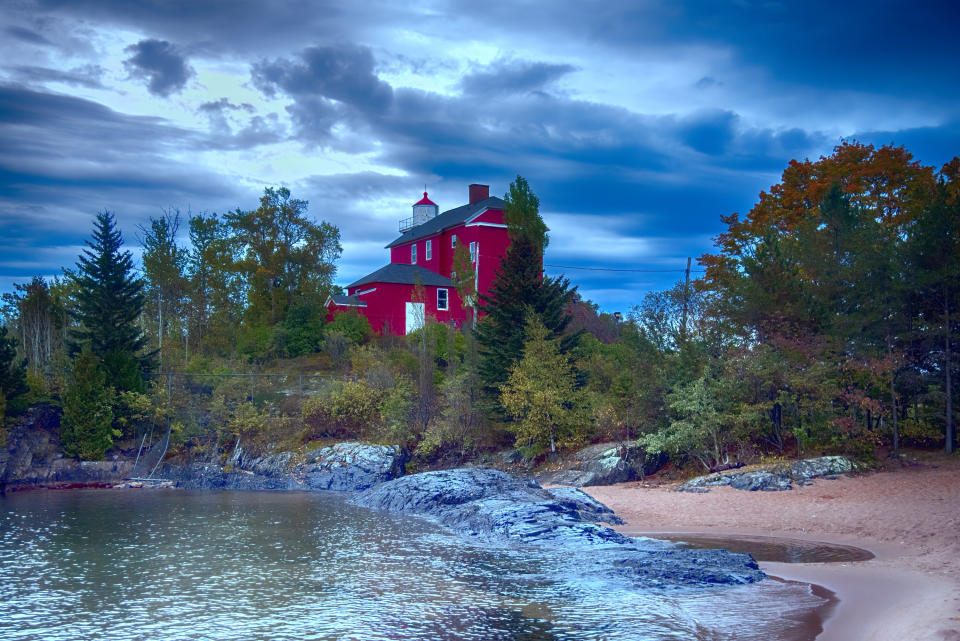 Red lighthouse on a rugged shoreline