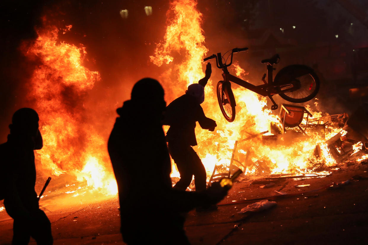 A demonstrator tosses a bicycle into an improvised bonfire during an anti-government protest in Santiago, Chile on Oct. 28, 2019. (Photo: Edgard Garrido/Reuters)