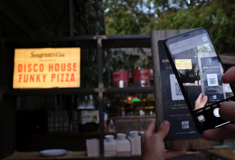 Client uses his mobile phone scans the QR code to place your order of a pizza with its ingredientes through of the "Funky Pay" app, where the app replaces waiters at Funky Pizza restaurant in Palafrugell