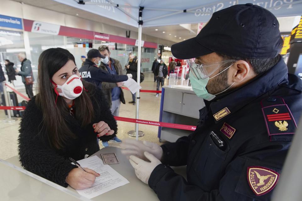 A traveler wears a mask as she fills out a form at a check point set up by border police inside Rome's Termini train station, Tuesday, March 10, 2020. In Italy the government extended a coronavirus containment order previously limited to the country’s north to the rest of the country beginning Tuesday, with soldiers and police enforcing bans. (AP Photo/Andrew Medichini) (Photo: ASSOCIATED PRESS)