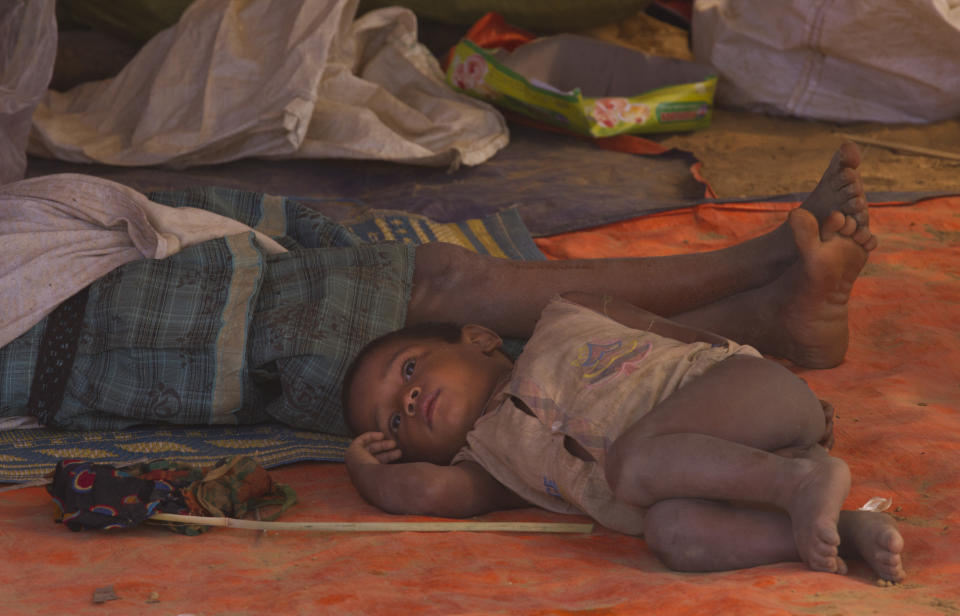 In this Thursday, Jan. 18, 2018, file photo, a newly arrived Rohingya family rests under a temporary shelter at Balukhali refugee camp near Cox's Bazar, Bangladesh. United Nations agencies are warning that more than 350 million people in the Asia-Pacific are going hungry as the coronavirus pandemic destroys jobs and pushes food prices higher. (AP Photo/Manish Swarup, File)