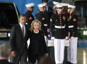 President Barack Obama walks with Secretary of State Hillary Clinton past the flag-draped transfer case of one of four Americans who died this week in Libya, during a transfer of remains ceremony at Andrews Air Force Base near Washington, September 14, 2012. U.S. Ambassador to Libya Christopher Stevens and three other Americans killed this week in Benghazi were honored at the ceremony. REUTERS/Jason Reed