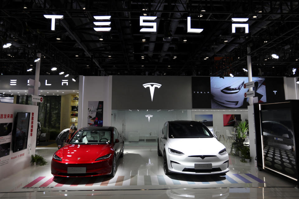 A staff member looks at Tesla's new Model 3 sedan displayed next to Model X SUV at the China International Fair for Trade in Services (CIFTIS) in Beijing, China September 2, 2023. REUTERS/Florence Lo/File Photo