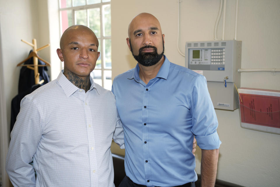 Kyle Vinson, left, stands with his attorney, Qusair Mohamedbhai, on Wednesday, Aug. 4, 2021, in Denver. Aurora Officer John Haubert was arrested Monday on suspicion of attempted first-degree assault, second-degree assault and felony menacing charges following a criminal investigation into the arrest last week of Vinson, who is biracial and identifies as Black. (AP Photo/David Zalubowski)