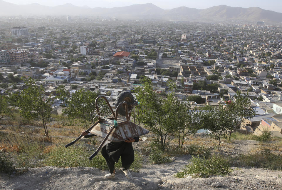 An Afghan boy carries his wheelbarrow in Kabul, Afghanistan, Monday, Aug. 5, 2019.(AP Photo/Rafiq Maqbool)